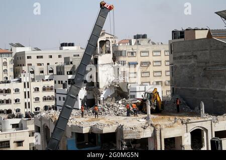 Gaza. 1er juin 2021. Les travailleurs palestiniens retirent les décombres d'un bâtiment détruit par des frappes aériennes israéliennes dans la ville de Gaza le 1er juin 2021. Naji Sarhan, sous-secrétaire du ministère des travaux publics et du logement de la bande de Gaza, dirigé par le Hamas, a déclaré à Xinhua que le bombardement israélien de l'enclave côtière avait détruit les infrastructures, y compris les bâtiments résidentiels, les usines et les hôpitaux. On estime que 1,100 logements ont été complètement détruits et que 900 autres ont été partiellement détruits et rendus inhabitables. Credit: Rizek Abdeljawad/Xinhua/Alamy Live News Banque D'Images