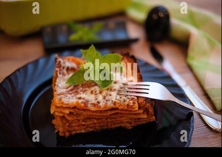 Gros plan d'une lasagne au fromage servie sur une assiette noire Banque D'Images