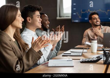 Réunion réussie. Collègues ayant suivi une formation en salle de réunion, se claquant les mains Banque D'Images