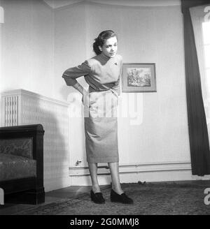 Dans les années 1950. Une jeune femme tient ses mains sur le bas du dos et regarde comme elle a la douleur de cette partie de son corps. Suède 1951 réf. BB81-10 Banque D'Images