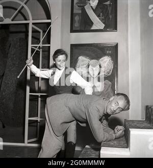 Dans les coulisses du théâtre des années 1950. La jeune actrice Elisaveta, 1922-1992 ans, tient une canne tandis que l'acteur Egon Larsson s'est engagé à recevoir sa punition. Juste bon amusement et pas pour vrai. Suède 1953 réf. BM28-11 Banque D'Images