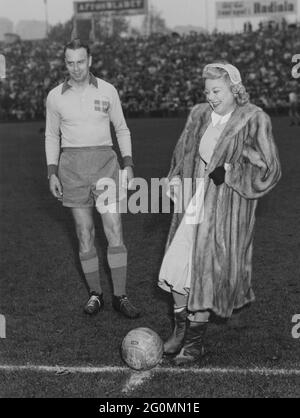 Sonja Henie. Champion norvégien de patinage artistique, né en avril 8 mort en octobre 12 1969. Photo au début du match de football entre la Suède et la Norvège sur le stade Råsunda le 18 1953 octobre. Le capitaine de l'équipe suédoise Gösta Lindh regarde. Banque D'Images