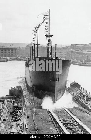 Chantier naval dans les années 1920. Un navire est lancé dans le port de Göteborg et le quai de Götaverken. Une photographie majestueuse du bateau qui glisse dans l'eau. C'est le nouveau navire Shantung de la Swedish East India Companys qui sera lancé le 7 1929 juin. La société a une longue histoire de commerce avec l'Inde de l'est et a utilisé leurs propres navires. Banque D'Images