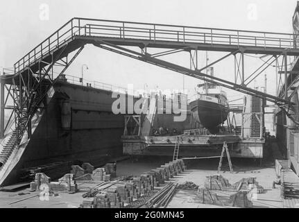 Chantier naval 1918. Une photo rare montrant un quai flottant et un petit bateau dessus, à l'intérieur d'un énorme quai flottant. Ceci pour pouvoir faire des travaux à la fois sur le fond du quai et l'entretien sur le bateau en même temps. Photo prise au chantier naval de Götaverken à Göteborg au printemps 1918. Banque D'Images