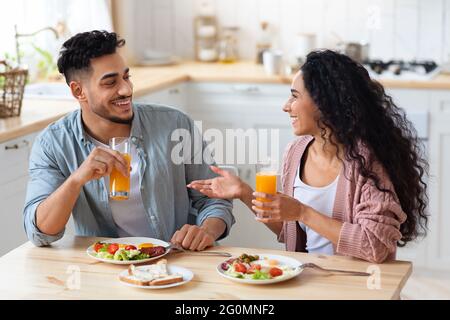 Joyeux jeune couple arabe prenant le petit déjeuner ensemble à la maison Banque D'Images