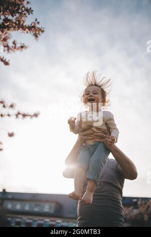 Le père jette son enfant dans l'air. Banque D'Images