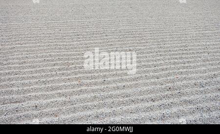 Texture de gravier qui est rachée en vagues de lignes droites, comme celles dans le jardin japonais. Banque D'Images