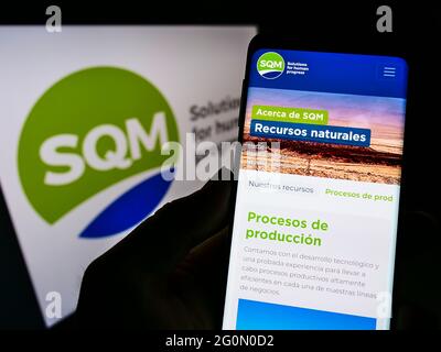 Personne tenant le téléphone portable avec la page web de la société Sociedad Química y Minera de Chile (SQM) à l'écran avec logo. Concentrez-vous sur le centre de l'écran du téléphone. Banque D'Images