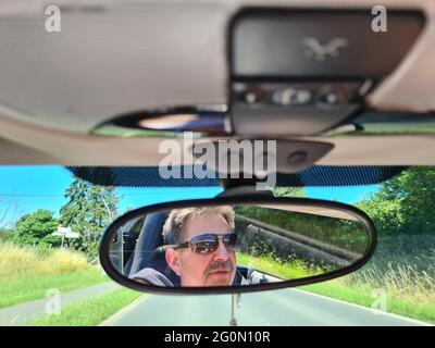 Vue arrière du conducteur mâle regardant le rétroviseur intérieur de la voiture Banque D'Images