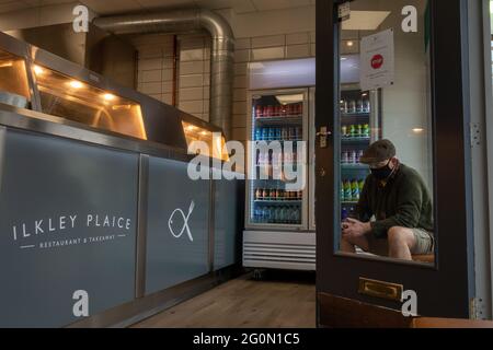 À l'intérieur d'une nouvelle boutique de poissons et de puces (avec une personne portant un masque et un chapeau plat) à Ilkley qui a ouvert pendant la pandémie de Covid, Ilkley, West Yorkshire, U Banque D'Images