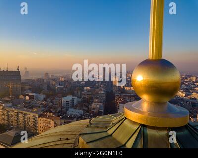 Photo aérienne de la croix dorée sur le sommet de la cupola du temple de Saint Sava à Belgrade avec Terazije et le bâtiment Beogradjanka en arrière-plan Banque D'Images