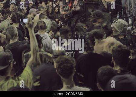 Foule de concertgoers à un festival de musique punk hardcore, plongée sous scène, jeu de groupe, photo prise avec la technique de photographie hdr double exposition. Banque D'Images