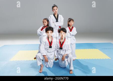 Les jeunes entraîneurs enseignent aux élèves l'apprentissage du tae kwon do Banque D'Images