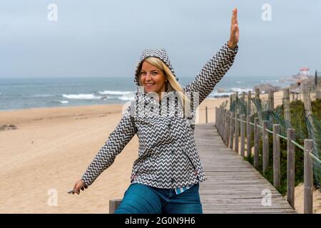 Femme souriante posant sur UNE passerelle en bois à Porto, Portugal Banque D'Images