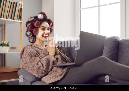 Jeune femme regardant l'écran de son ordinateur portable excitée à gagner loterie en ligne Banque D'Images