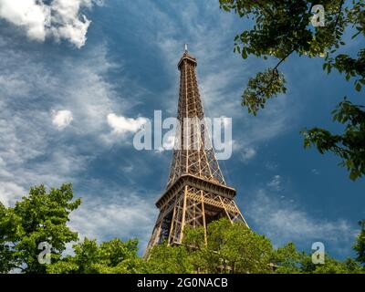 Paris, France, mai 2021. Tour Eiffel de la photo du bas entre les arbres, soirée ensoleillée, vue du bas, fond bleu, espace libre pour le texte Banque D'Images