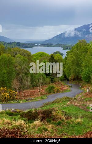 La route vers Ashness Bridge avec Derwent Water et Keswick en arrière-plan, Lake District, Angleterre Banque D'Images