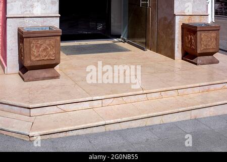 seuil en granit avec marches à l'entrée du magasin avec tapis de sol et poubelle en pierre pots à la façade de l'architecture de style européen bâtiment de près vi Banque D'Images