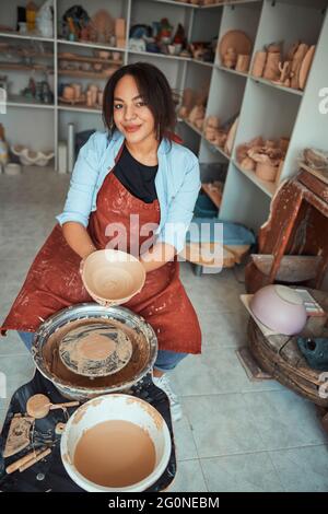 Belle jeune femme céramiste travaillant dans un atelier de poterie Banque D'Images