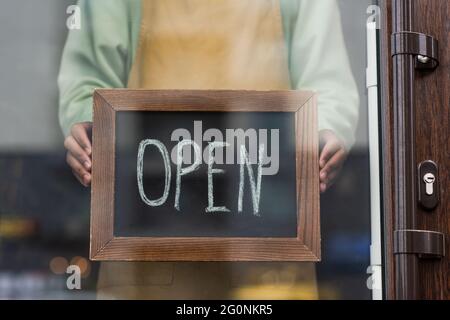 Vue rognée du barista afro-américain tenant un tableau noir avec un lettrage ouvert dans le café Banque D'Images