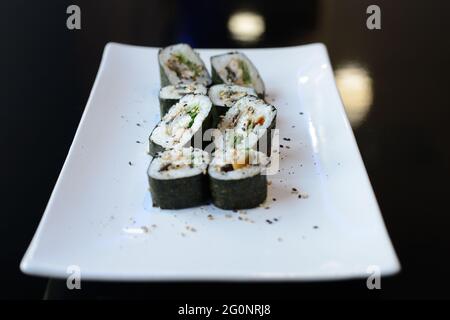 Petits pains à sushis sur un plat blanc. Banque D'Images