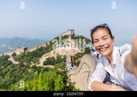 Selfie. Tourisme à la Grande Muraille de chine enthousiaste et heureux de s'amuser au célèbre Badaling pendant les vacances de voyage à destination touristique chinoise. Femme Banque D'Images