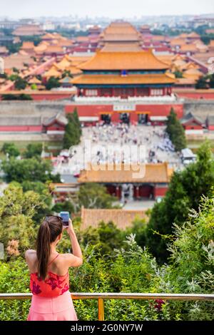 voyage d'été en chine. Femme touriste prenant des photos avec un téléphone portable de vue aérienne des palais impériaux, des vieux temples, la Cité interdite à Beijing Banque D'Images