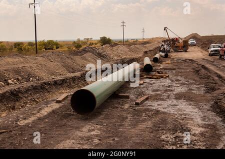 Gazoduc de gaz naturel construit dans le nord du Texas qui permet de commercialiser le gaz naturel. Les tuyaux soudés ensemble et enterrés embués transportent le gaz naturel des puits aux raffineries. La fracturation sous haute pression a ouvert de nouveaux et anciens champs pétroliers au Texas et a aidé à éloigner le pays de l'utilisation du charbon. Banque D'Images