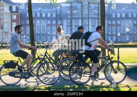 Münster, Allemagne. 2 juin 2021. Un groupe de jeunes pédalez devant Münster Schloss (palais de la ville) par une journée chaude et ensoleillée avec des températures autour de 28 degrés dans la ville universitaire de Münster. Le nombre de Covid a chuté régulièrement en Allemagne, ce qui a conduit à un assouplissement supplémentaire des restrictions. Münster se classe régulièrement parmi les villes les plus à incidence la plus faible de NRW. Credit: Imagetraceur/Alamy Live News Banque D'Images