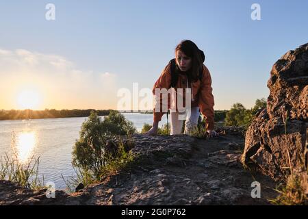 La fille monte sur une montagne rocheuse. Voyagez seul en dehors de la ville. Banque D'Images