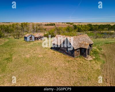 Une vue aérienne des anciennes fermes et bâtiments abandonnés qui ont été construits par les premiers colons agricoles de la Saskatchewan. Banque D'Images