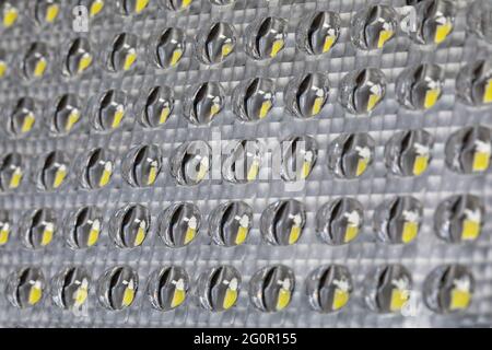 Fond de verre transparent de lampe LED ou panneau avec éléments de diodes électroluminescentes jaunes à l'intérieur. Mise au point sélective, fond de verre gla Banque D'Images