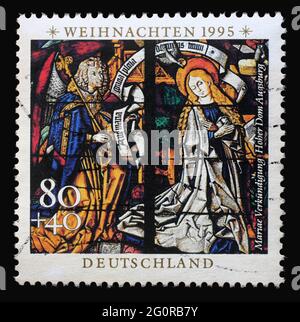 Un timbre imprimé en Allemagne montre l'Annonciation, vitraux de la cathédrale d'Augsbourg, vers 1995 Banque D'Images