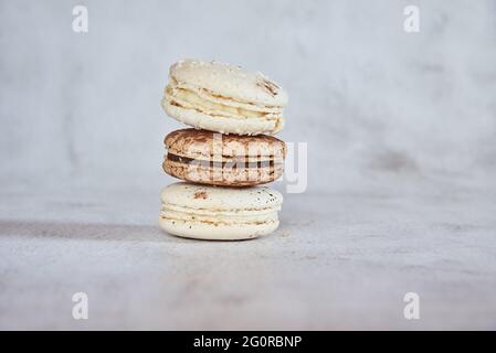 Le café et le macaron à la vanille sont empilés dans une pyramide sur un fond gris clair. Copier l'espace pour le texte, la conception. Banque D'Images