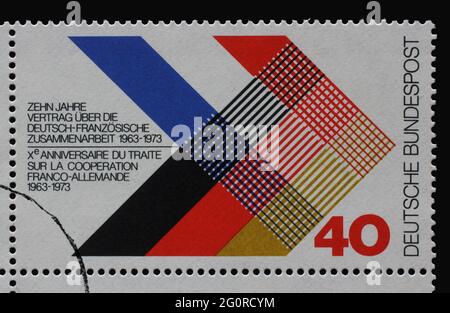 Un timbre imprimé en Allemagne dédié au 10e anniversaire de la collaboration germano-française 1963-1973 croisant les drapeaux de deux pays, vers 1 Banque D'Images