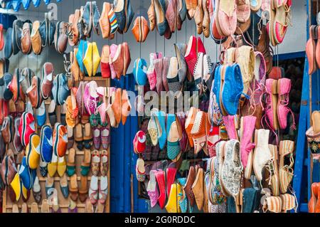 Des chaussures colorées sont accrochées devant un marché dans un souk. Banque D'Images