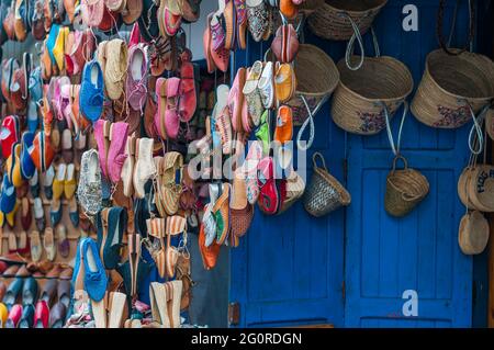 Des chaussures colorées sont accrochées devant un marché dans un souk. Banque D'Images