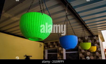 Superbe look avec pot de fleurs suspendu en plastique de différentes couleurs. Intérieur de la maison. En attendant l'été pour planter des fleurs Banque D'Images