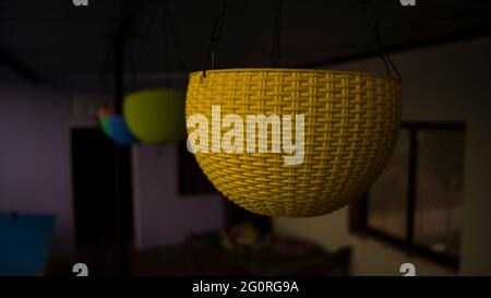 Superbe look avec pot de fleurs suspendu en plastique de différentes couleurs. Intérieur de la maison. En attendant l'été pour planter des fleurs Banque D'Images