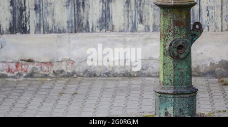 Très vieux avertissement vert hors service pompe à eau de rue debout le long de la chaussée avec l'espace de copie Banque D'Images