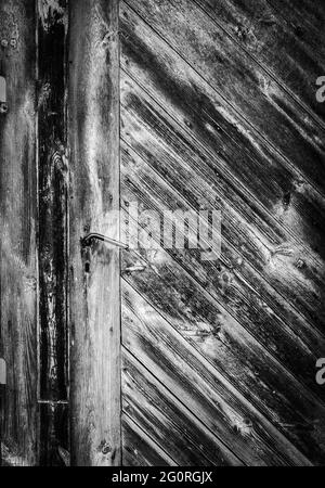 Très ancienne porte en bois avec poignée en métal et presque pas de peinture, image en noir et blanc Banque D'Images