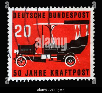 Timbre imprimé en Allemagne, montre un bus de poste de 1906 sur fond rouge. Le timbre-poste a été publié à l'occasion de 50 ans d'automi Banque D'Images