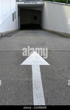 Entrée à un parking souterrain avec une flèche blanche indiquant la direction. Banque D'Images