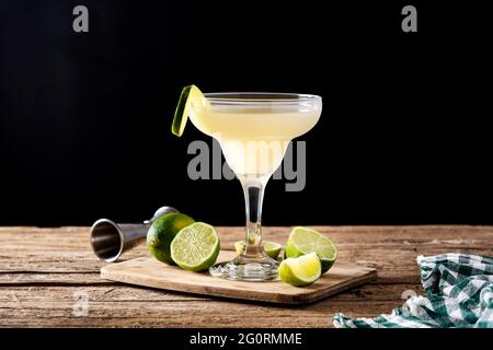 Cocktail daiquiri classique en verre sur table en bois et fond noir Banque D'Images