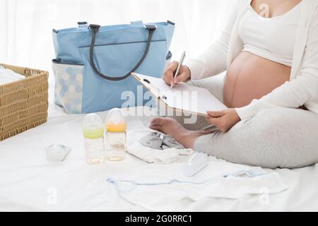 Femmes enceintes prénatales planning calendrier et liste de contrôle appareil pour bébé, préparer les ustensiles pour la grossesse concept Banque D'Images