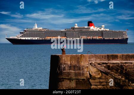 Une femme prend un selfie à côté du bateau de croisière Queen Victoria au large de Torbay à Devon, au Royaume-Uni. Banque D'Images