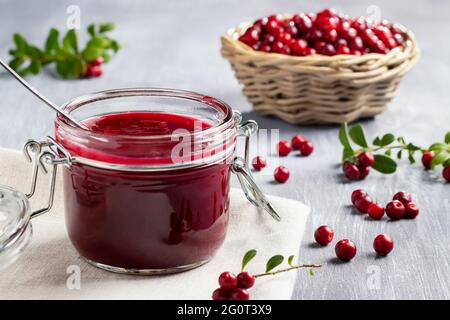 Pot en verre avec sauce maison aux baies de lingonis. Mise en conserve de la sauce aux baies de lingonis. Banque D'Images