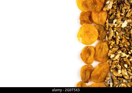 Noix et abricots séchés sur fond blanc avec place pour le texte. Fond de fruits secs Banque D'Images