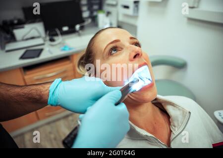 Une adolescente de race blanche assise dans une chaise de dentiste ayant les dents nettoyées Banque D'Images