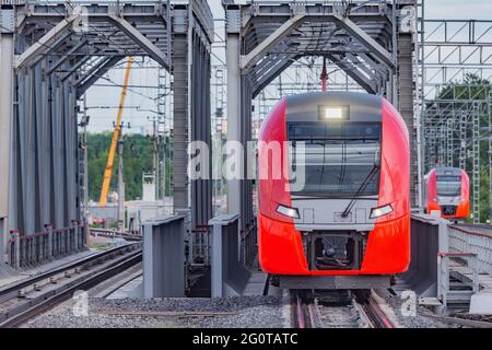 Le train à grande vitesse traverse le pont en approchant de la plate-forme de la gare. Banque D'Images